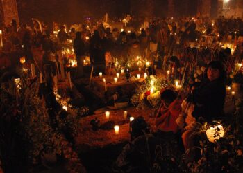 Papel picado, flores y velas en Día de Muertos