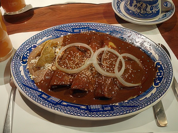 Enchiladas de Mole Poblano con frijoles refritos.